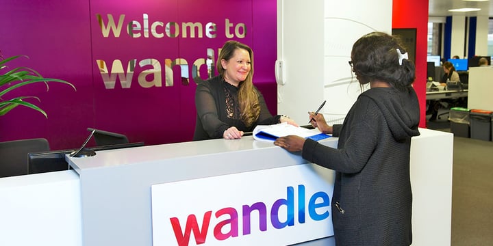 Customer is signing a document at a Wandle Housing Association Desk.