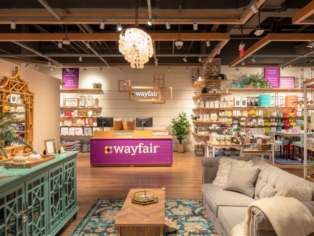 A wayfair store with wooden themed interior, splashes of purple adding color to it.