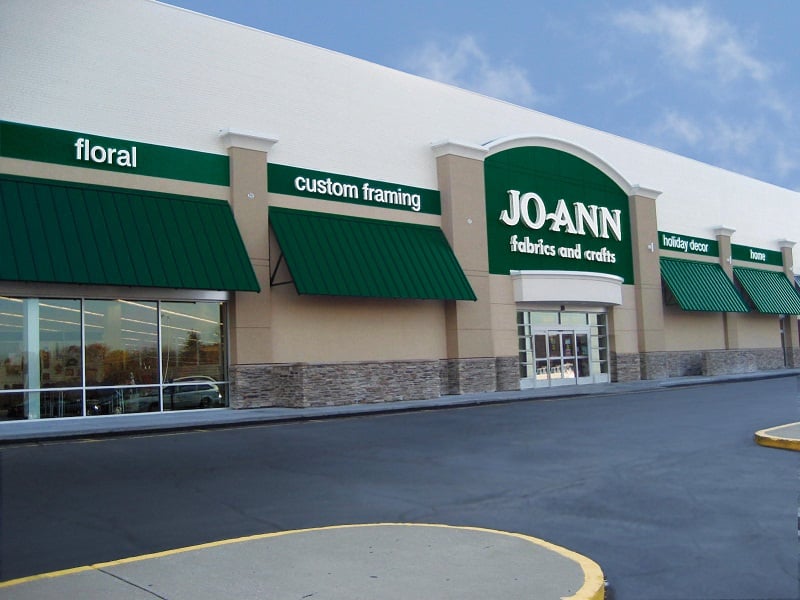 An image of JOANN's store with a green and white theme displays for different departments like floral, custom farming, holiday décor, and home.