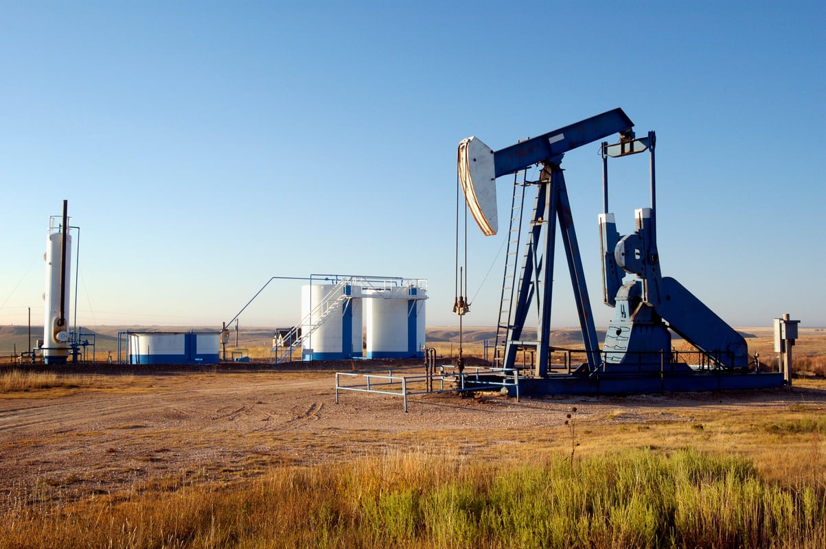 In an arid plain, an oil pump of  EOG Resources Inc operates close to many storage tanks