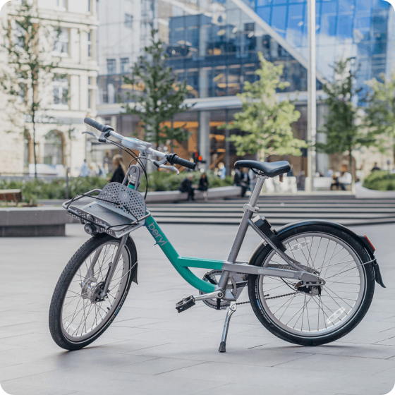 A Beryl bike standing against a city landscape.