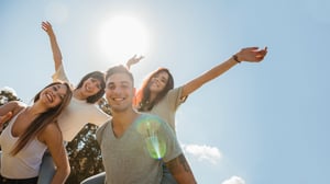 group-friends-raising-arms-sky-background