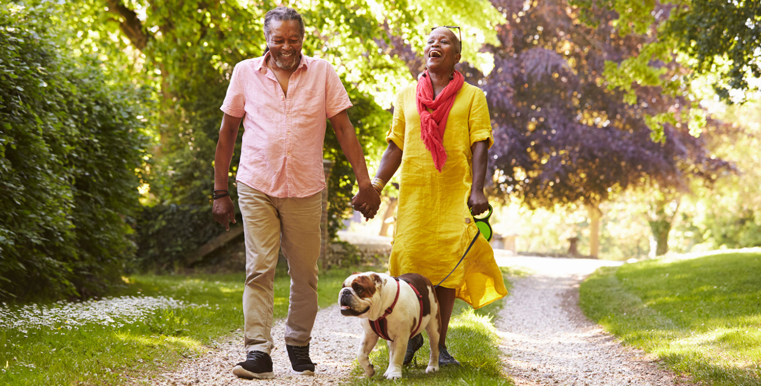 happy middle aged couple walking dog