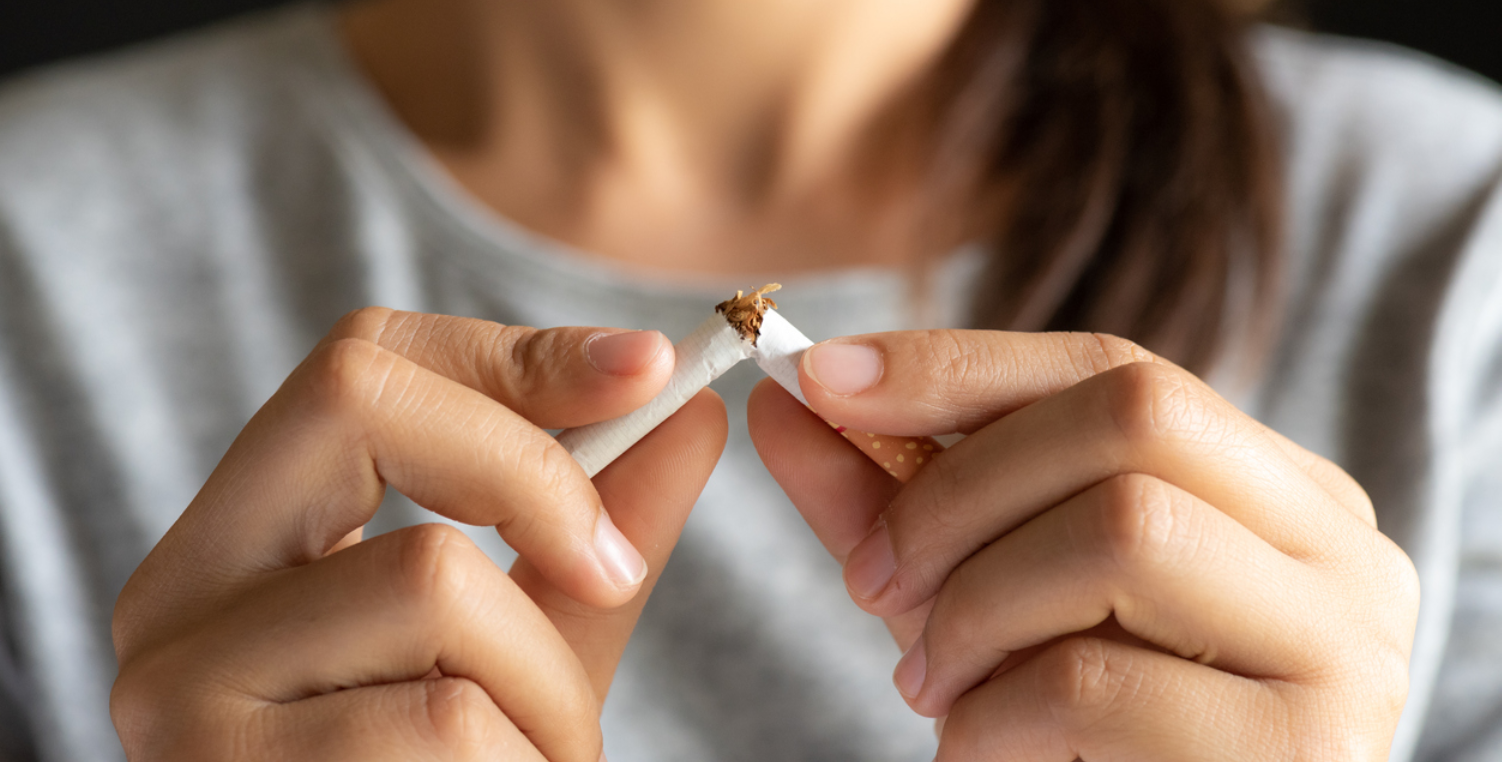 woman breaking cigarette to stop smoking