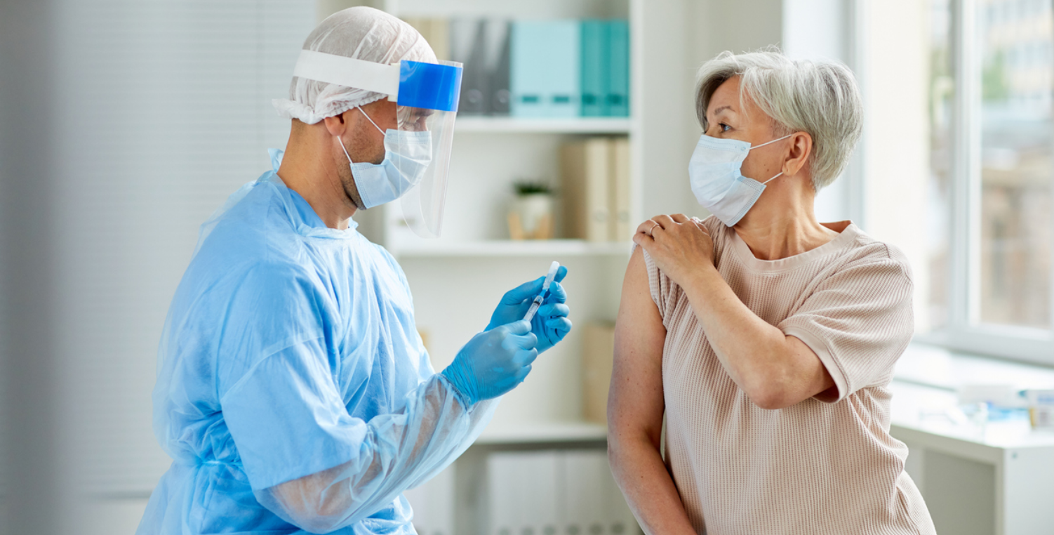 woman getting vaccine wearing PPE