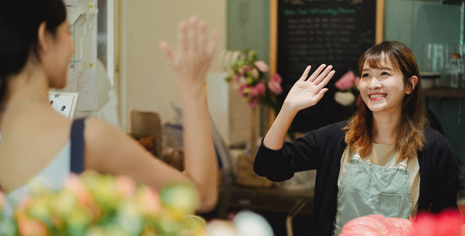 business owner waving to customer