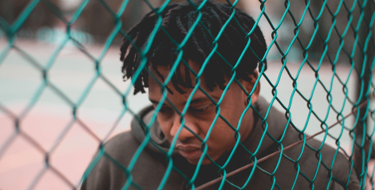 forlorn man by fence