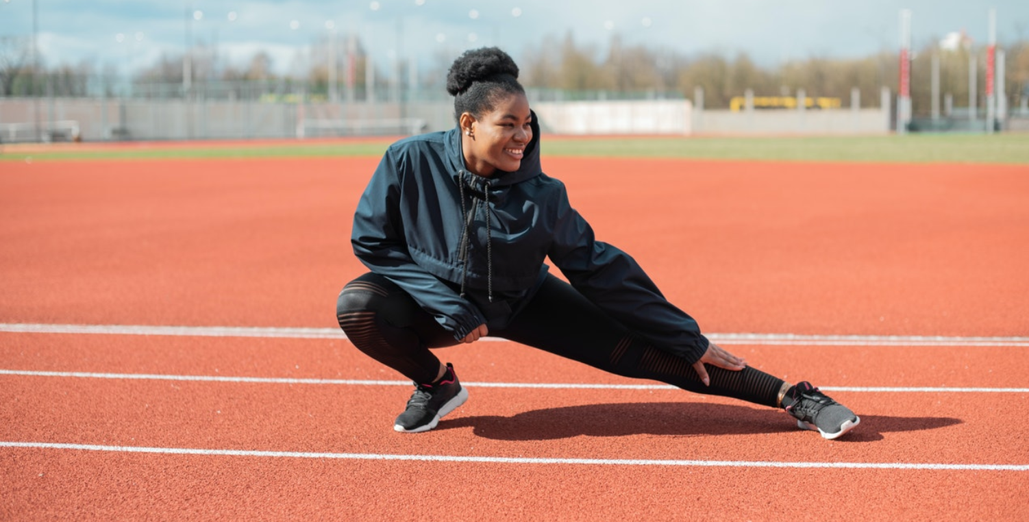woman stretching on track
