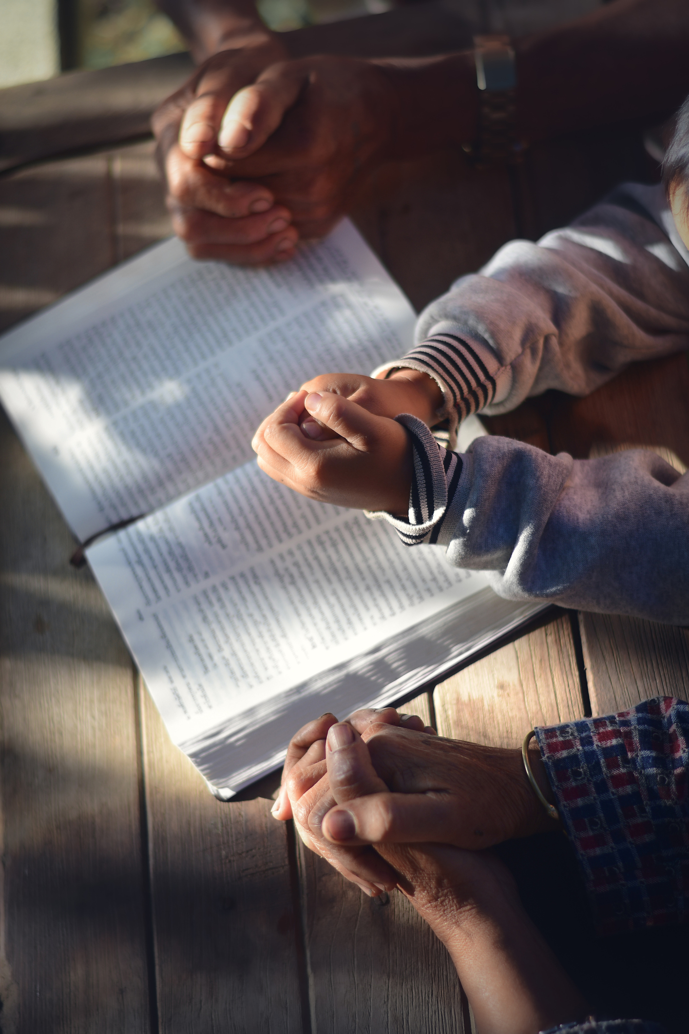 three people praying together