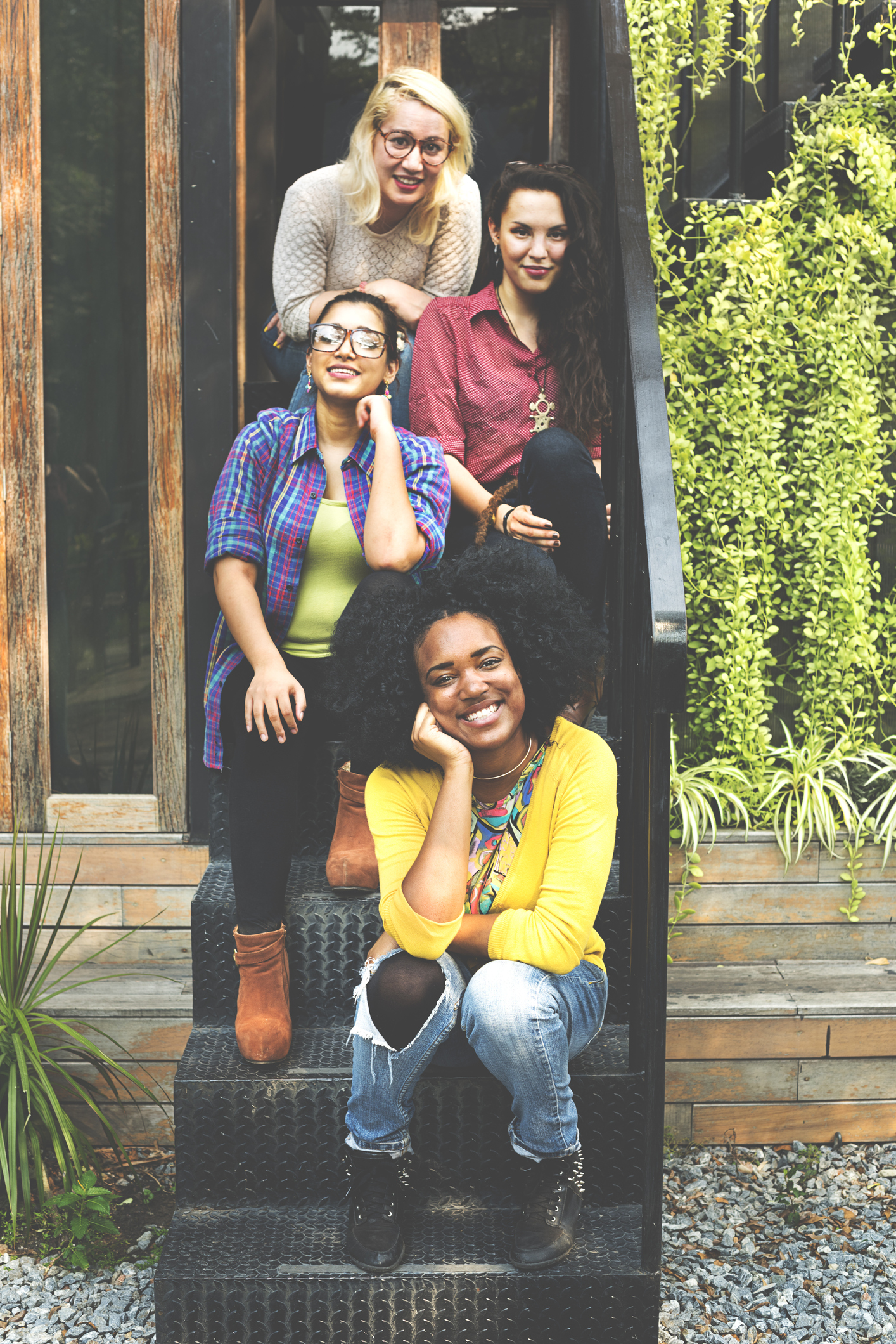 group of four female friends sitting on front stoop