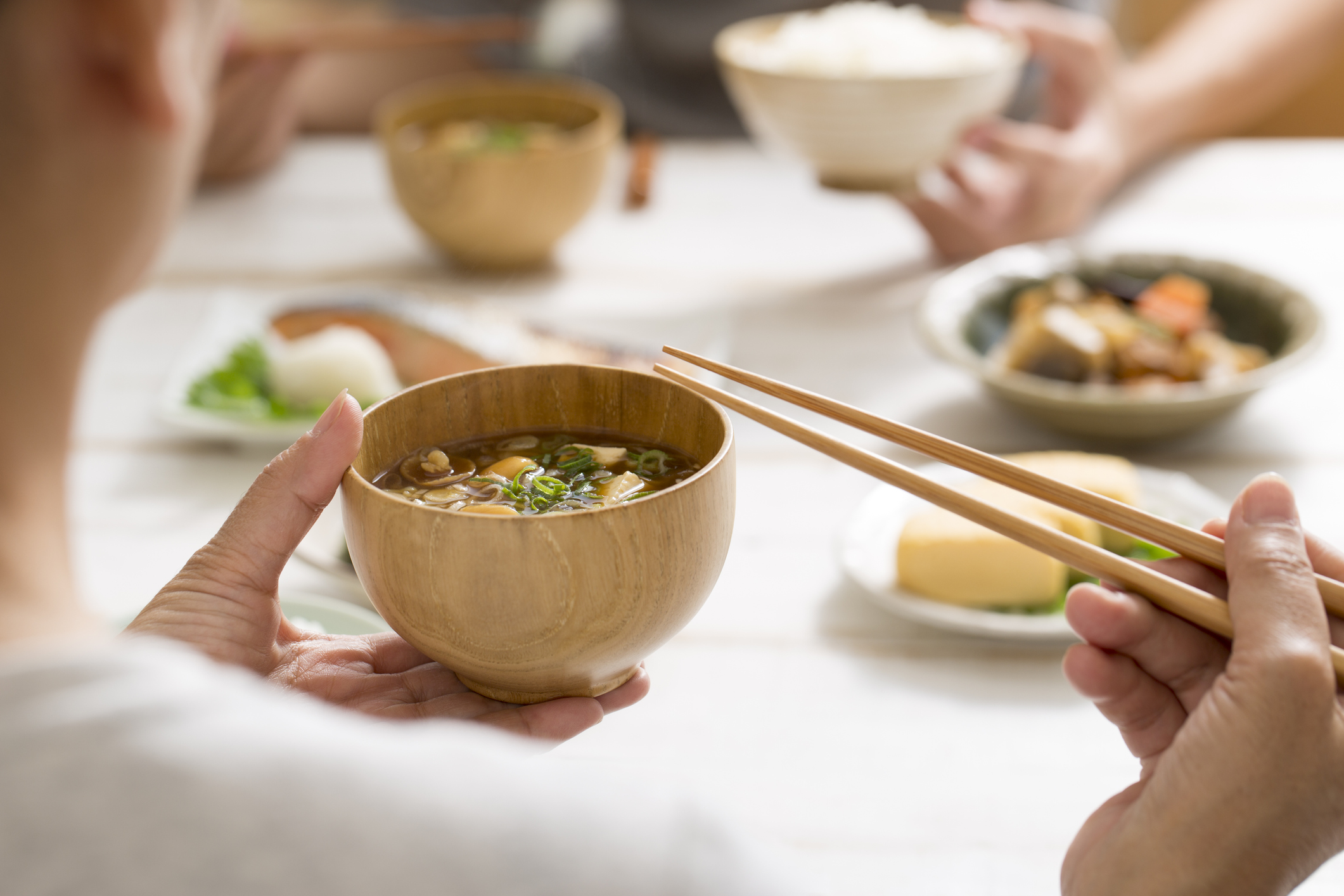 person pausing while eating bowl of japanese noodles
