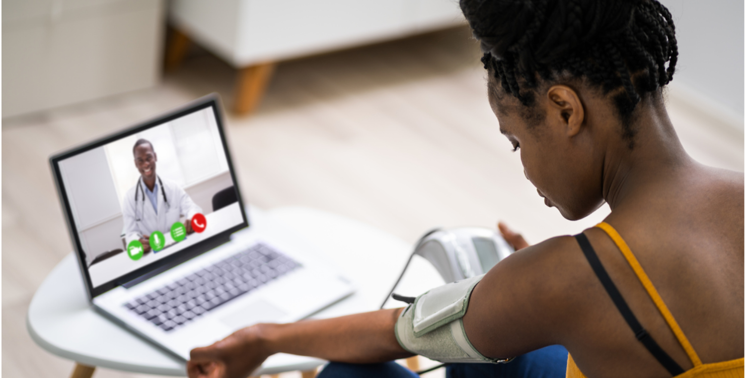 woman taking blood pressure during telehealth visit
