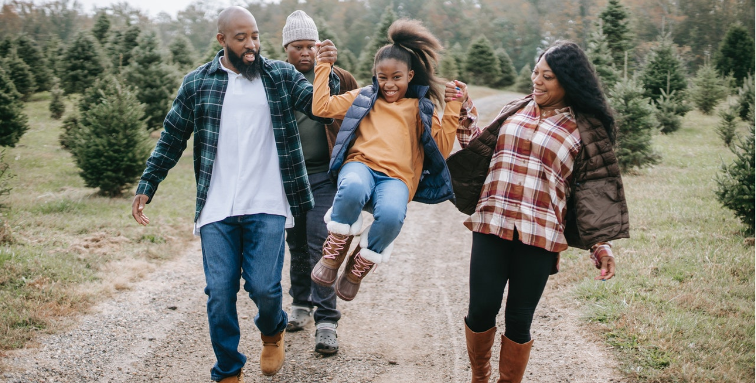 Family walking through Christmas tree farm