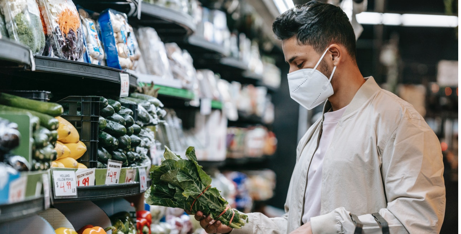 man buying produce in a mask.