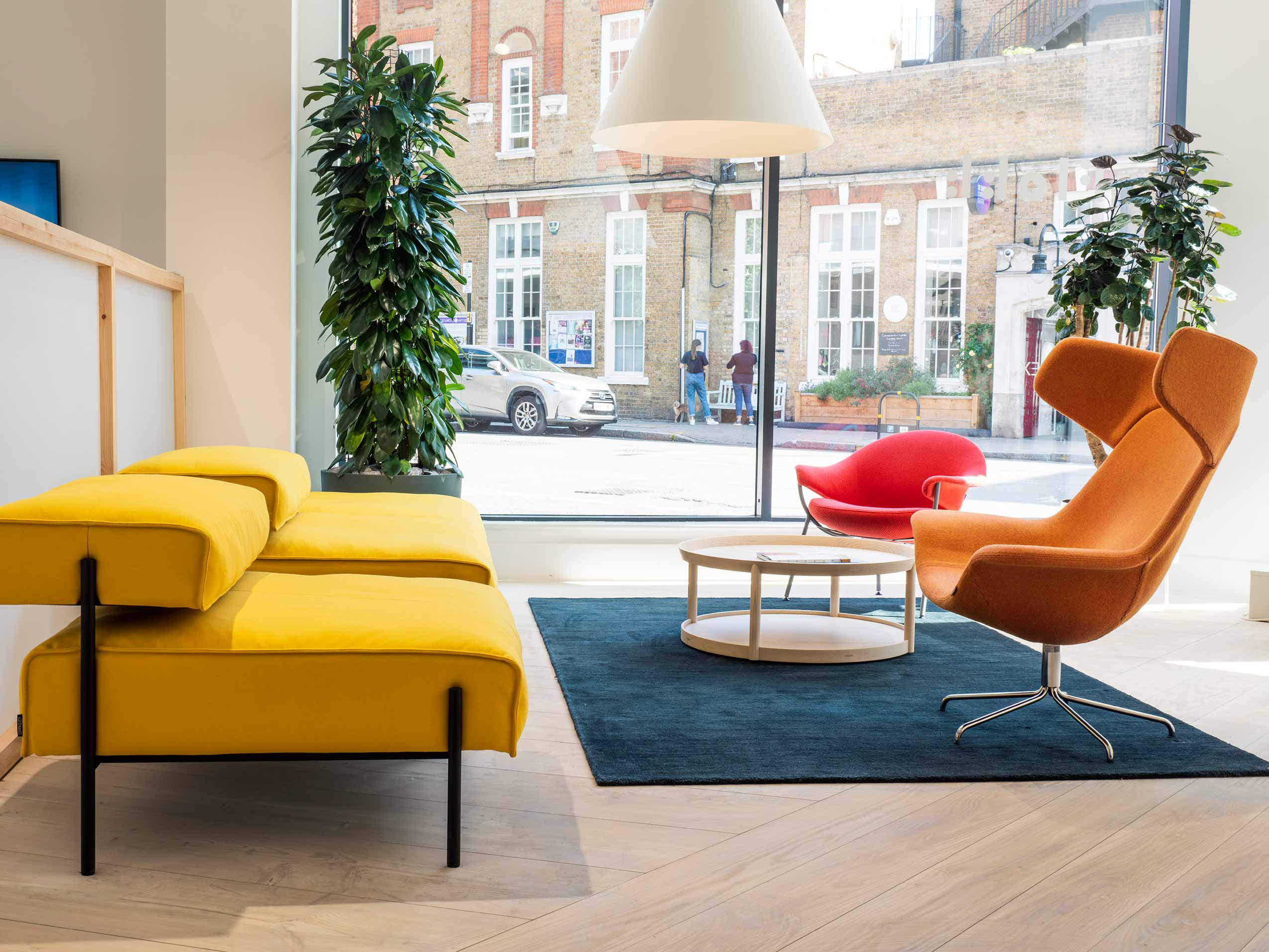UK Flokk showroom featuring OFfecct yellow sofa, red and orange chairs