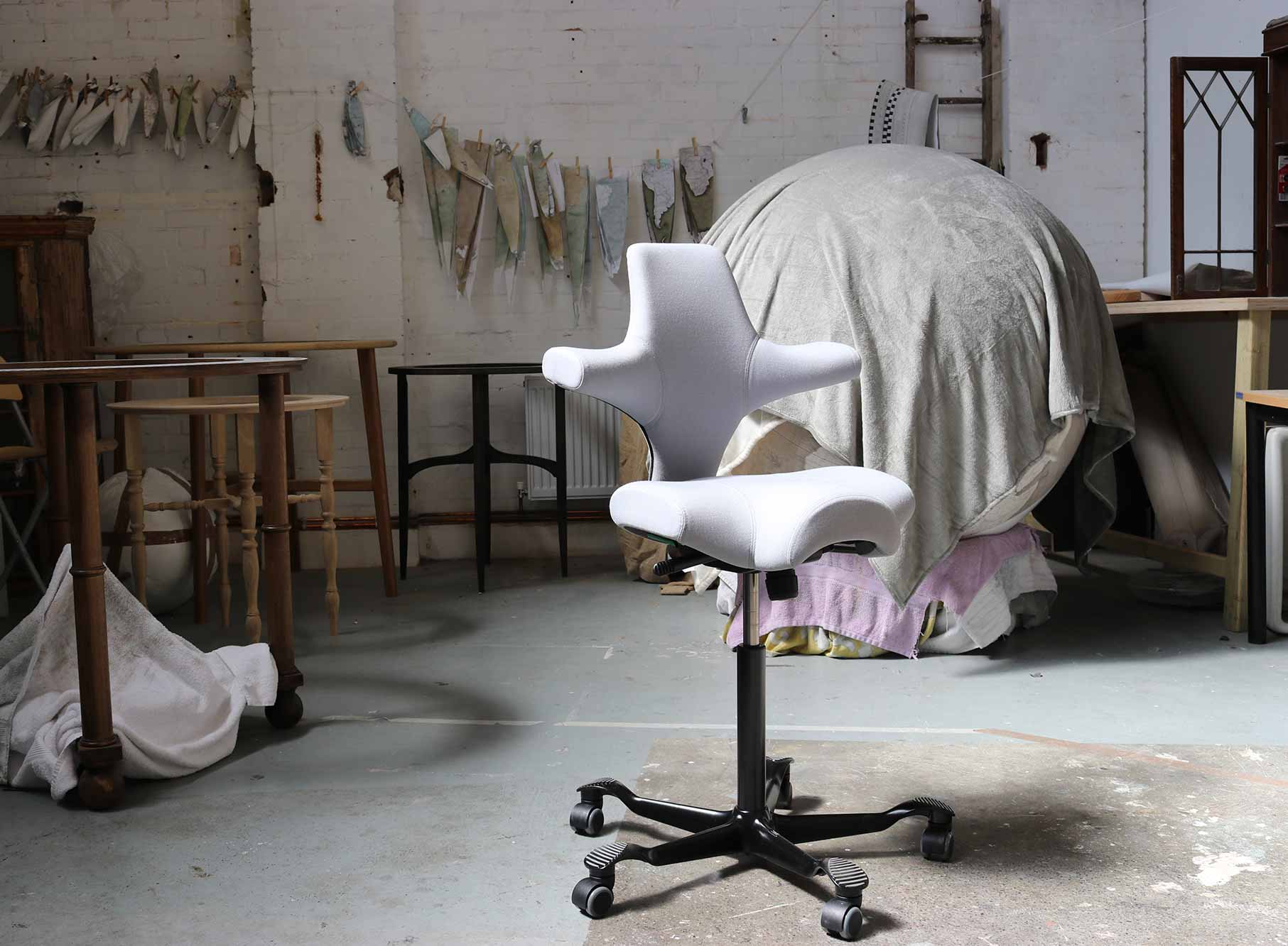Grey HÅG Capisco chair in bellerby & co workshop with giant globew covered in a cloth in the background