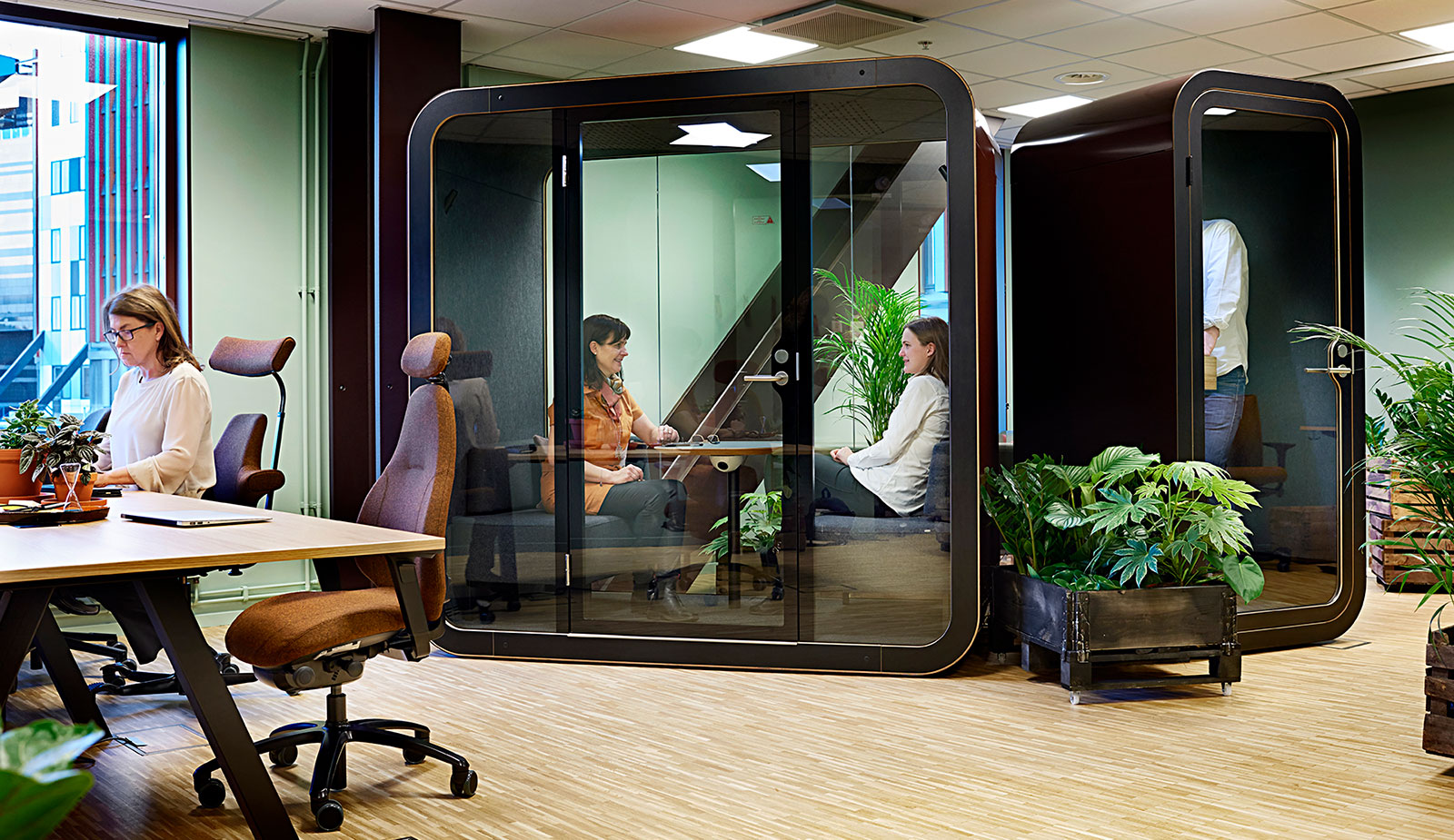 2 people inside a glass meeting booth in coworking office pop in work in sweden