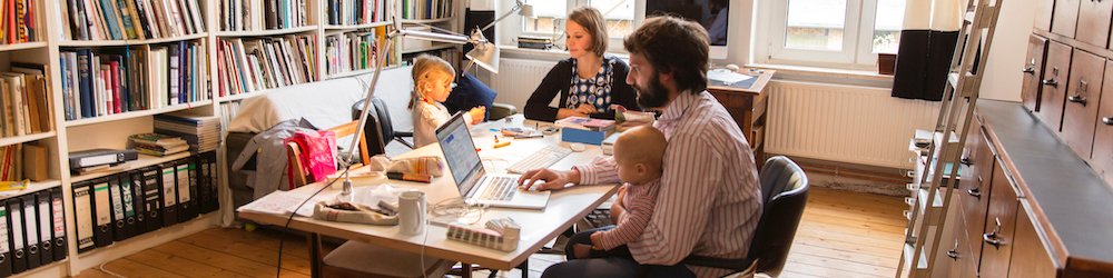 Young couple working from home with small children