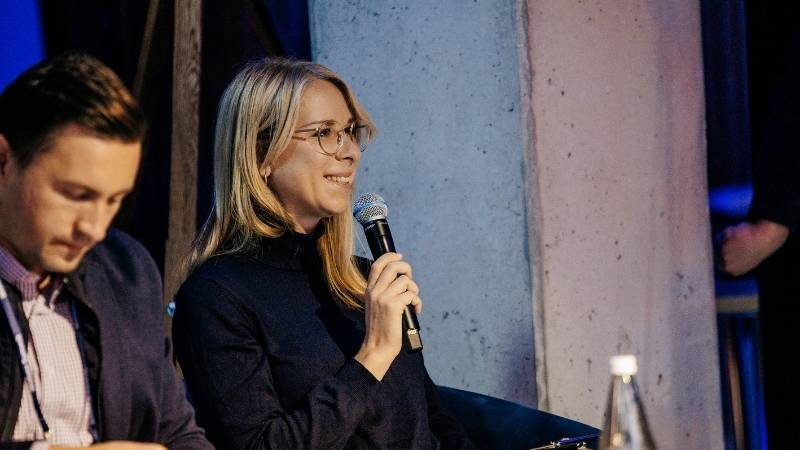 Marketing manager Swantje as jury member smiling and holding a microphone