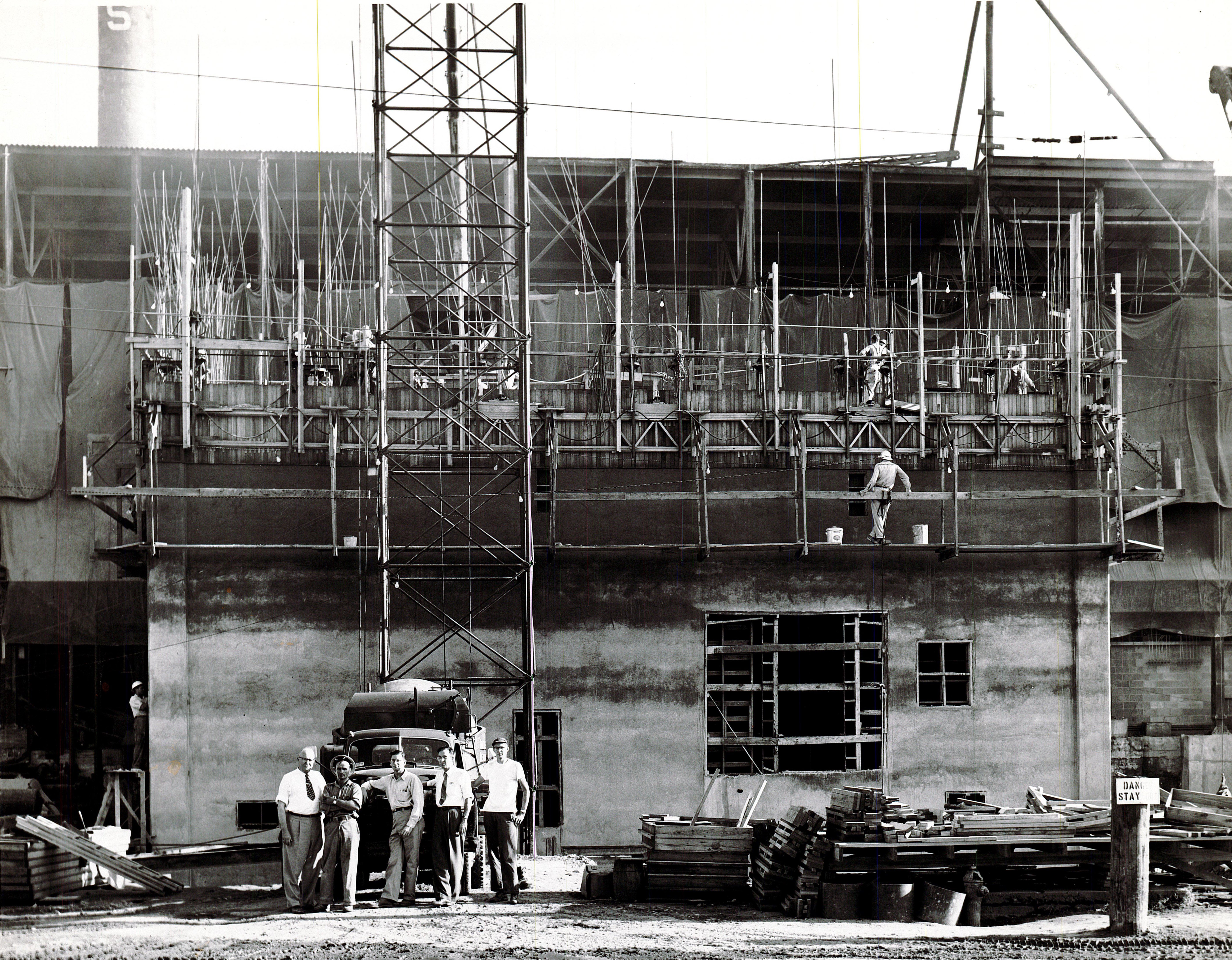 John Klug, pictured far left, overseeing the slipform construction of a new Klug batch house. 1954