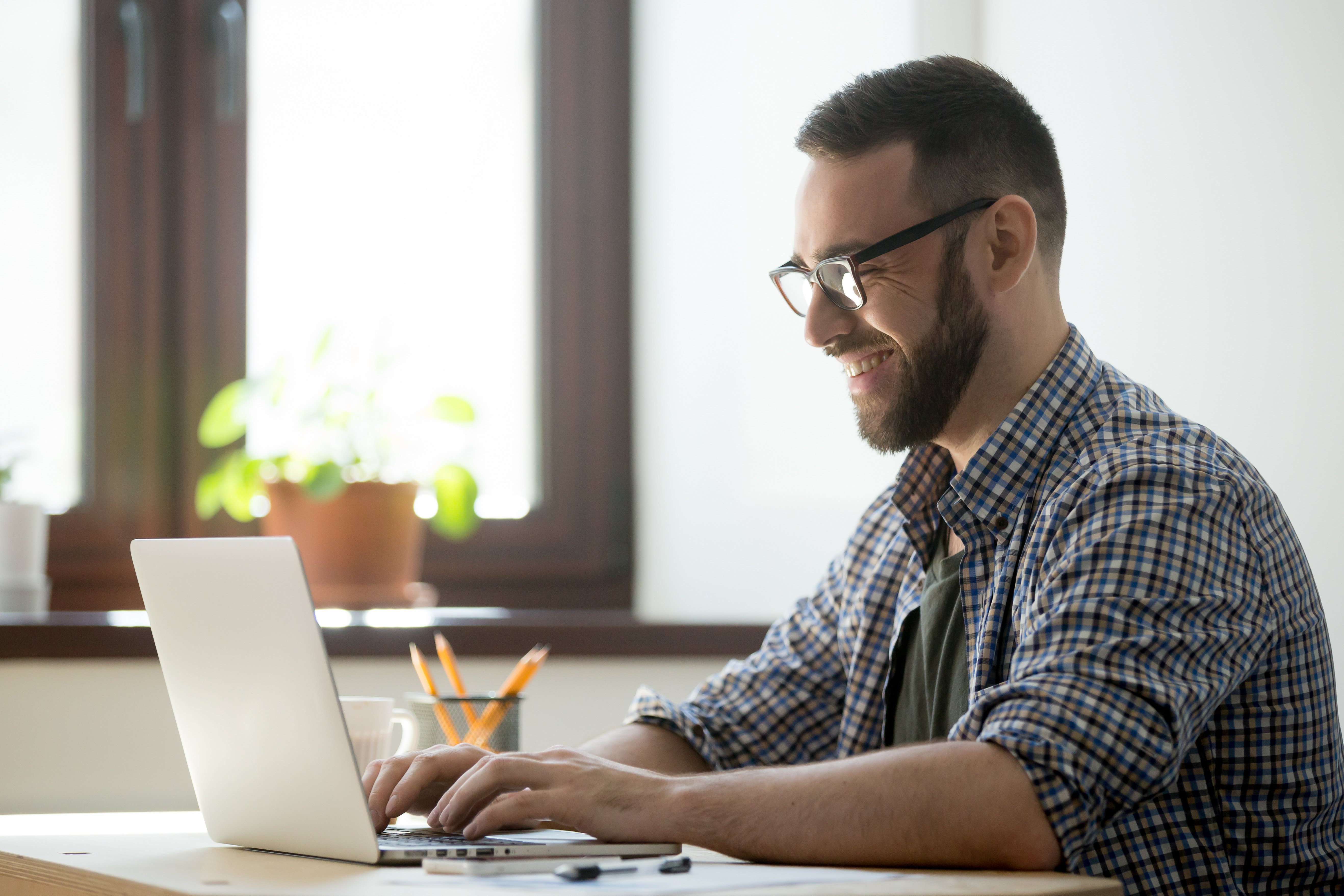 happy-male-writing-positive-mail-to-client