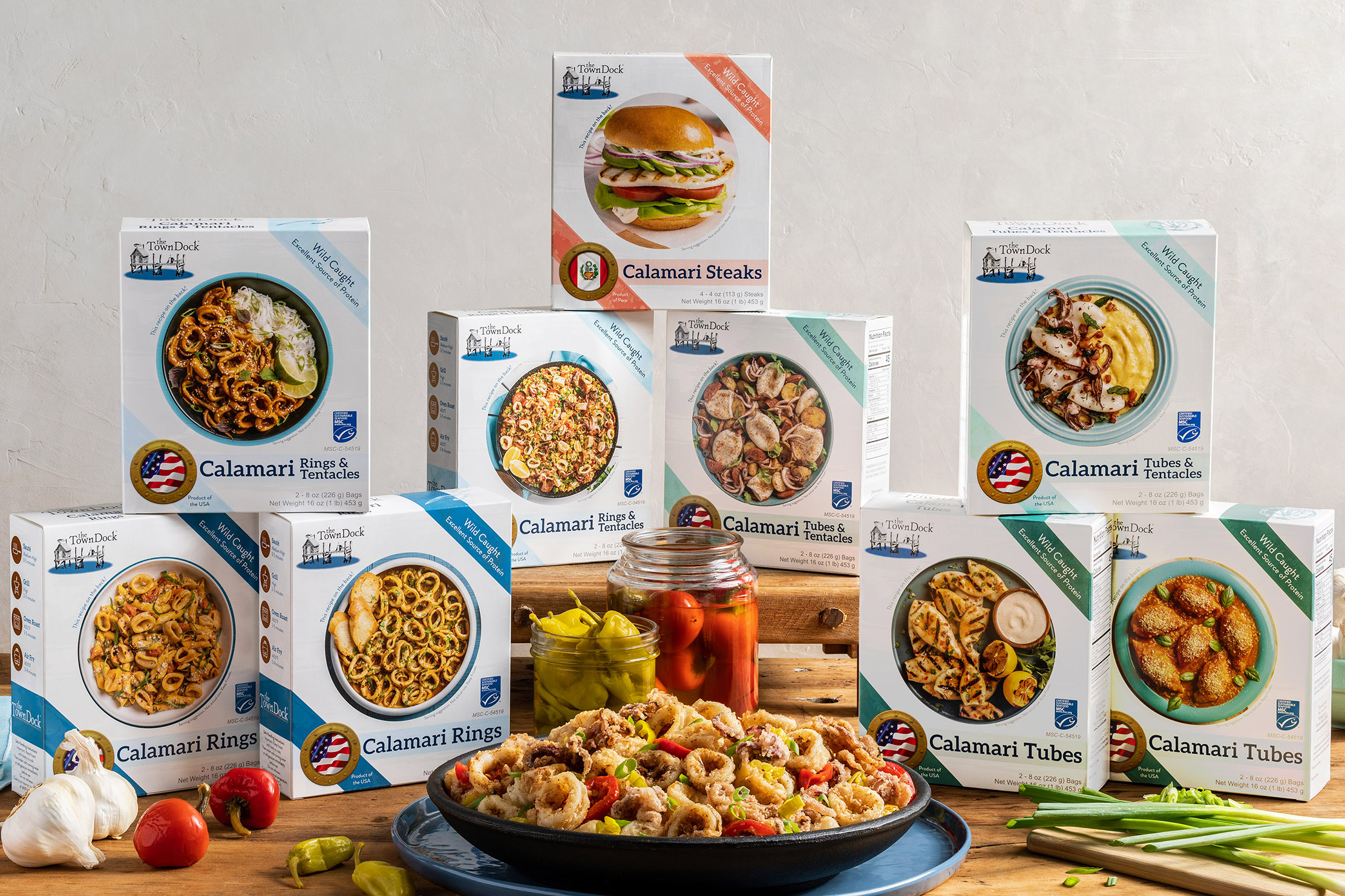 The nine retail boxes of Shortfin, Longfin, and calamari steaks stacked with a plate of fried calamari