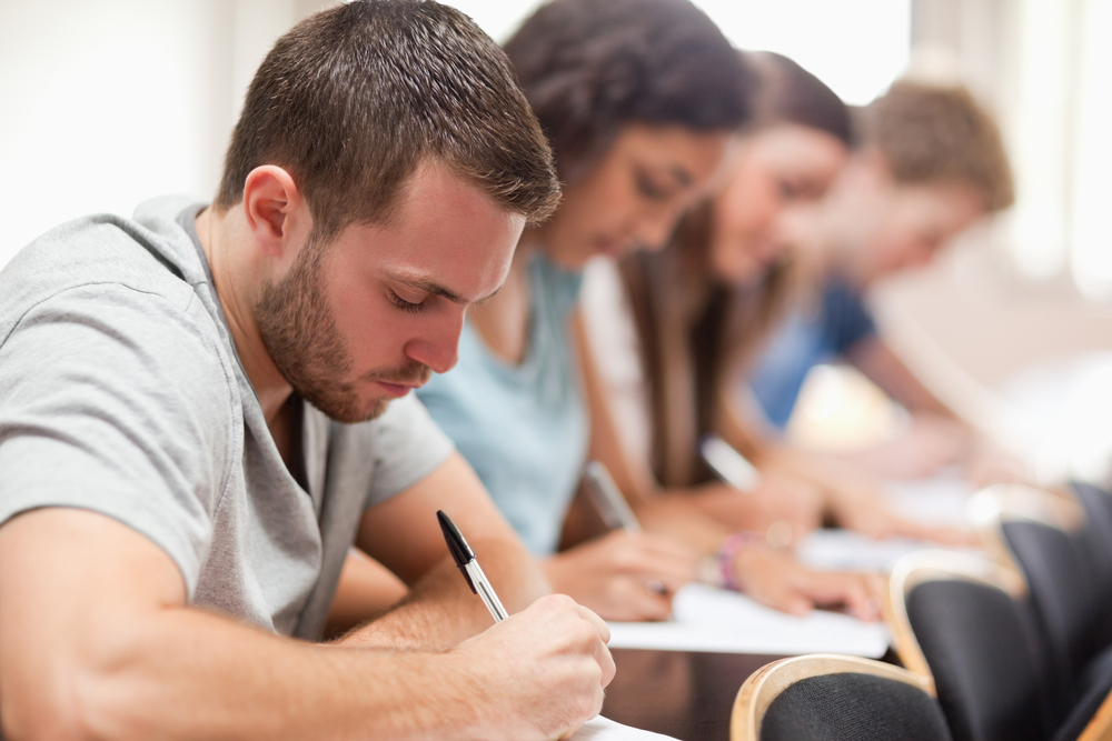 Serious students sitting for an examination in an amphitheater