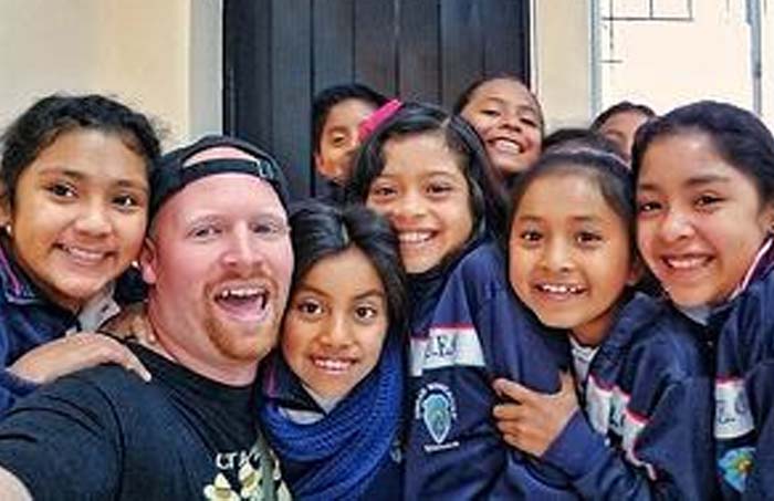 a male English Teacher in Ecuador and his students