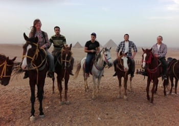 a group of English teachers in Egypt riding camels