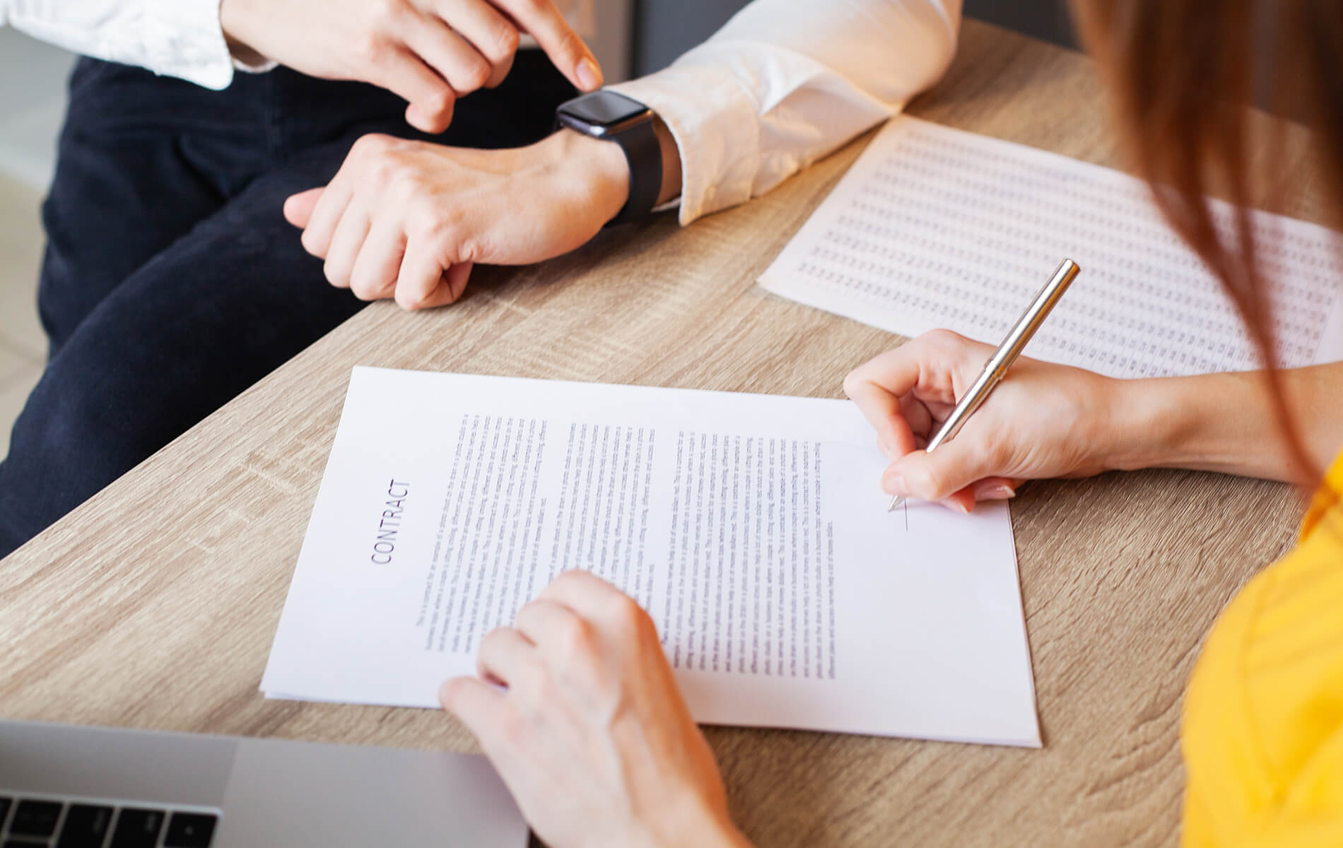 Mulher assina um contrato em uma mesa em um escritório da empresa