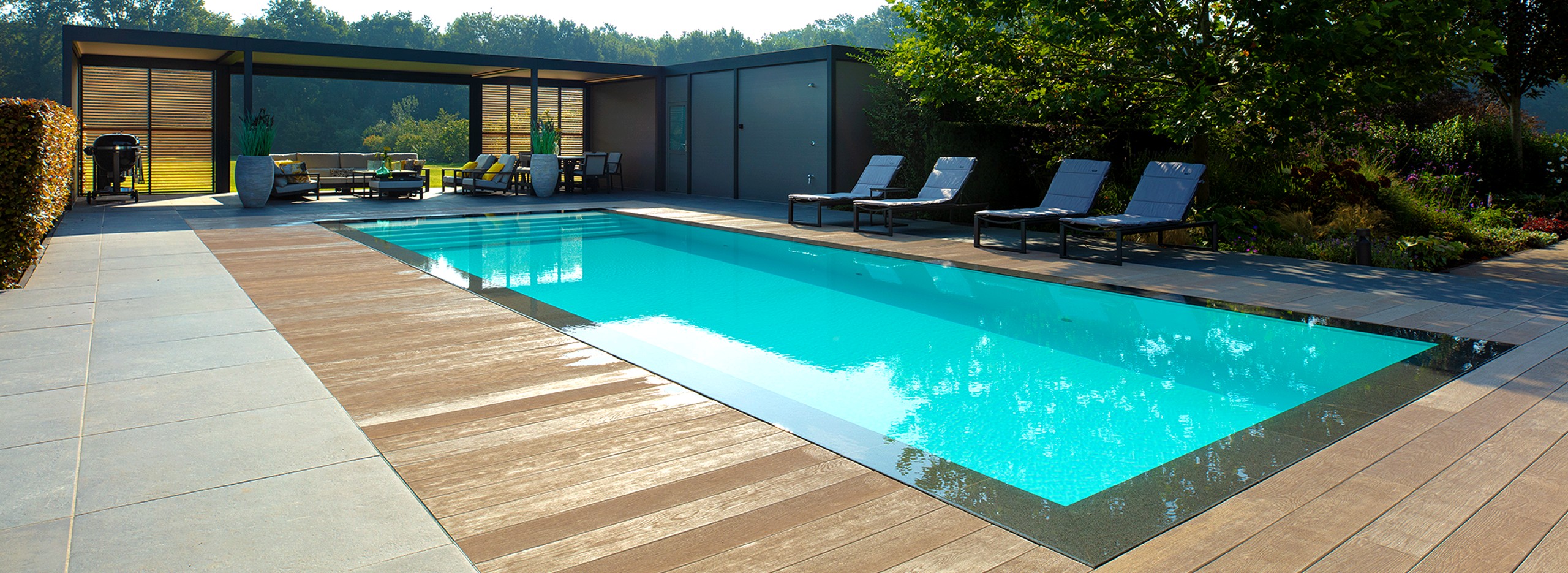 Infinity zwembad van starline naast riant poolhouse en met houten vlonder