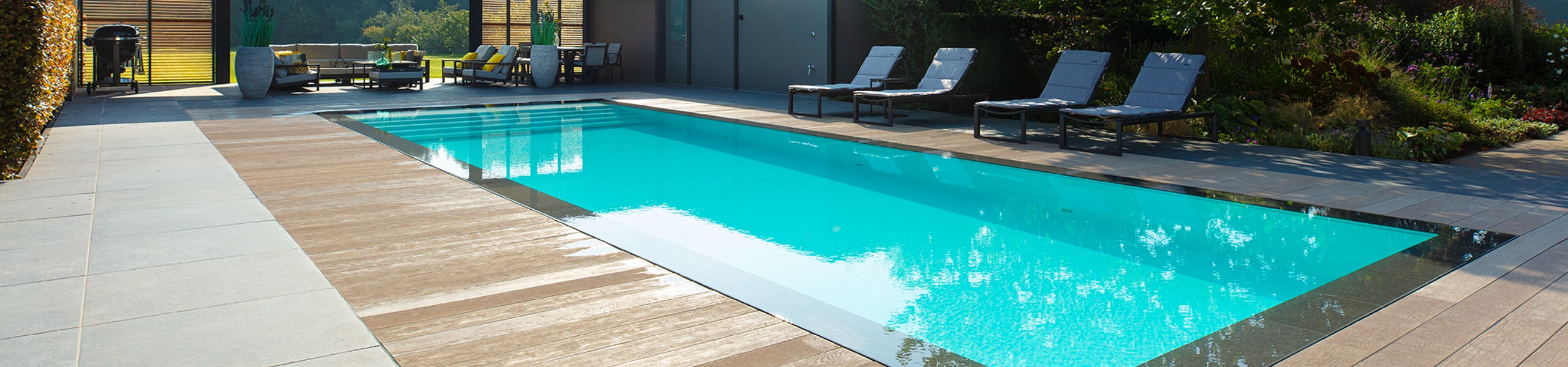 Starline infinity pool met poolhouse erachter en ruime houten vlonder
