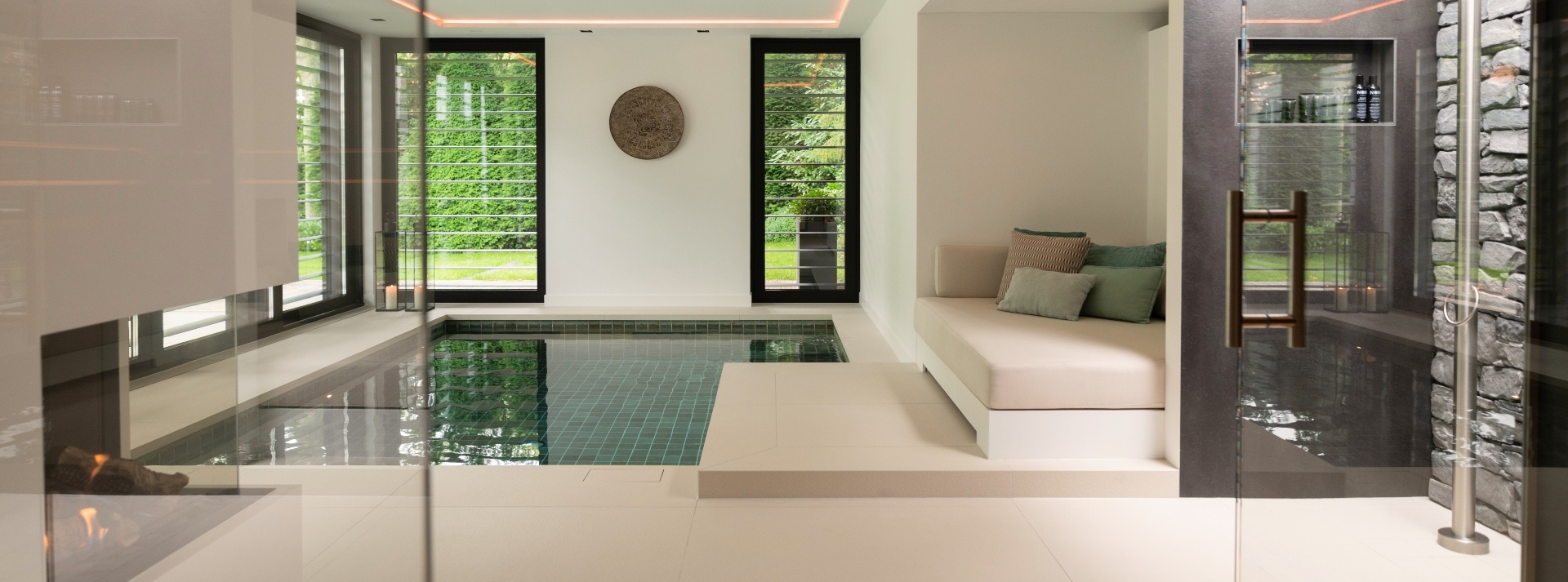 Bouwkundig binnenzwembad betegeld in luxe wellnessruimte