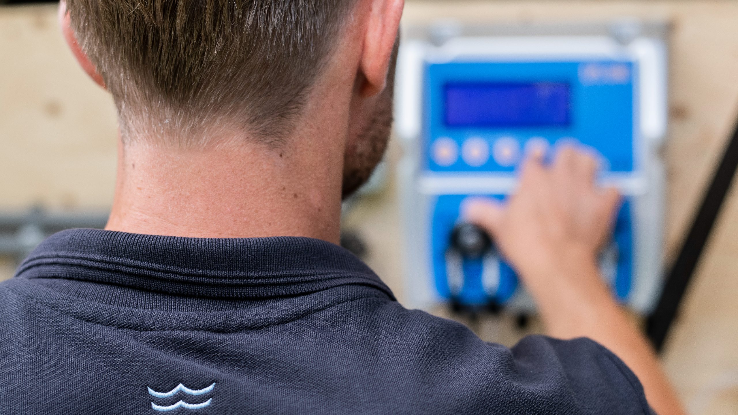 Servicemonteur voor zwembad en spa die aan knoppen van poolcontrol zit