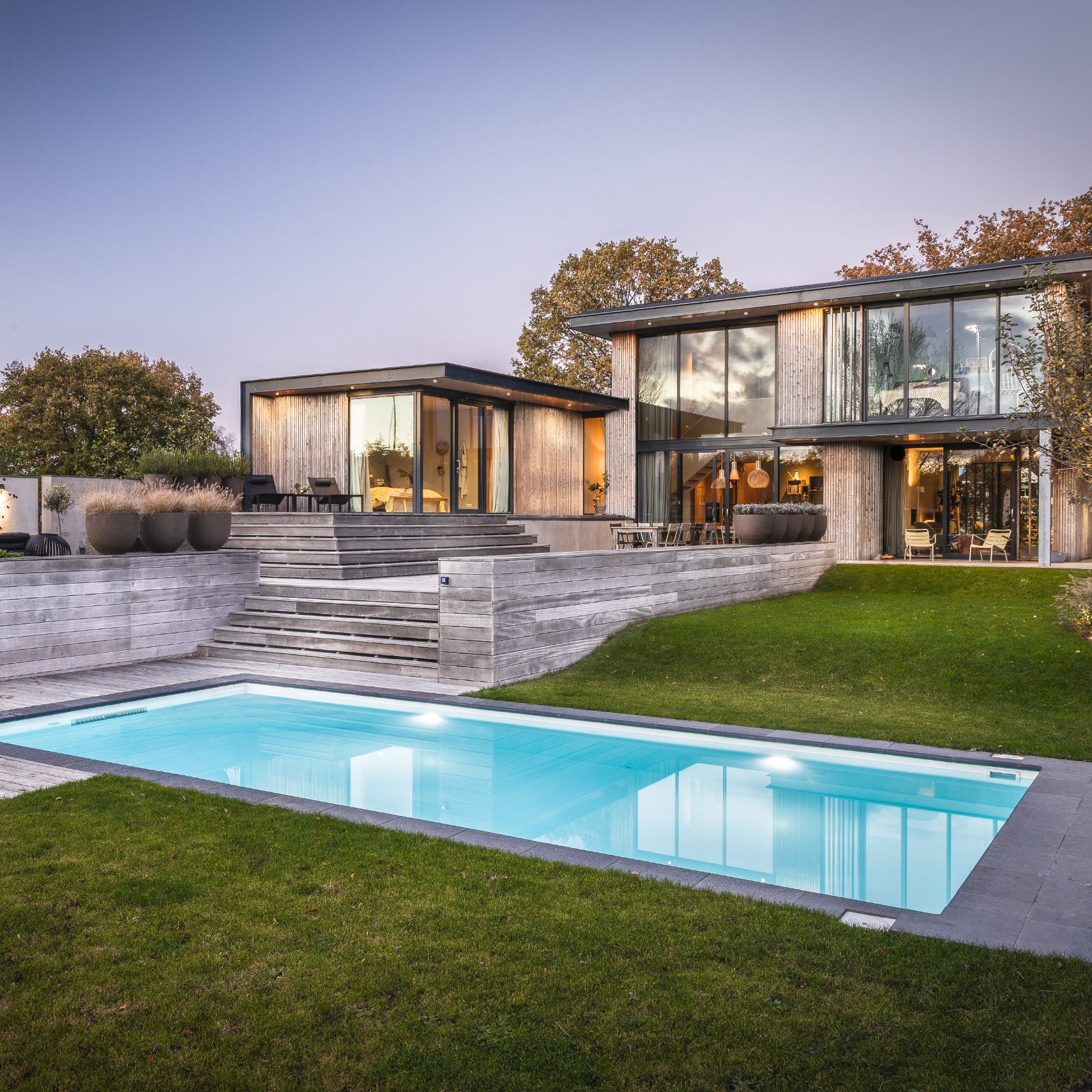 Welson zwembad in een luxe tuin met modern huis en gras