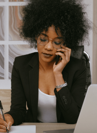 Photographie d'une femme passant un coup de téléphone au bureau.