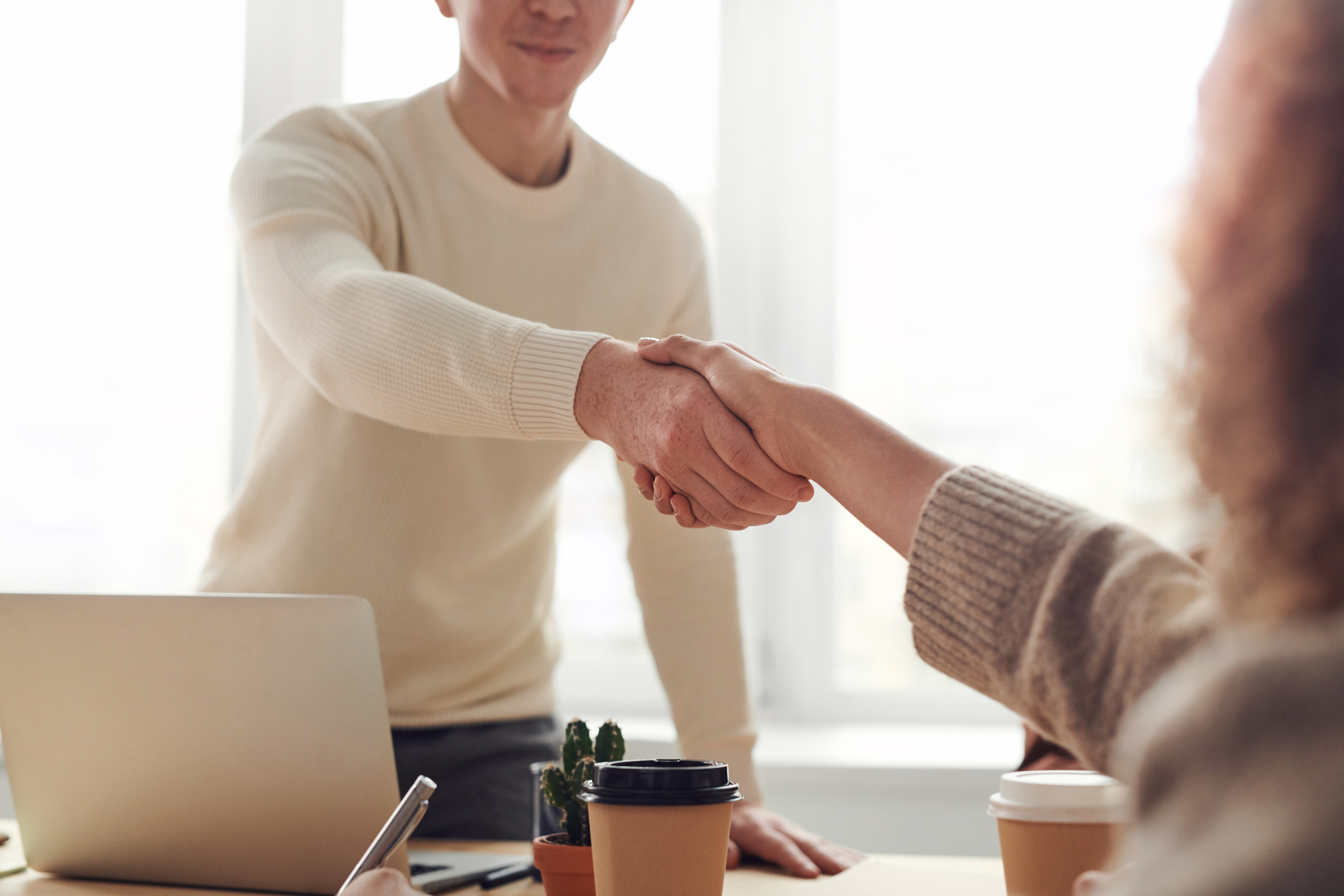 Photograph of two employees shaking hands.