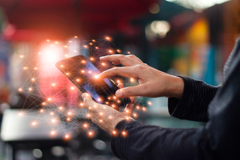 Man-using-mobile-smartphone-network-connection-at-night-on-city-shopping-street.-World-connected-and-social-networking-concept