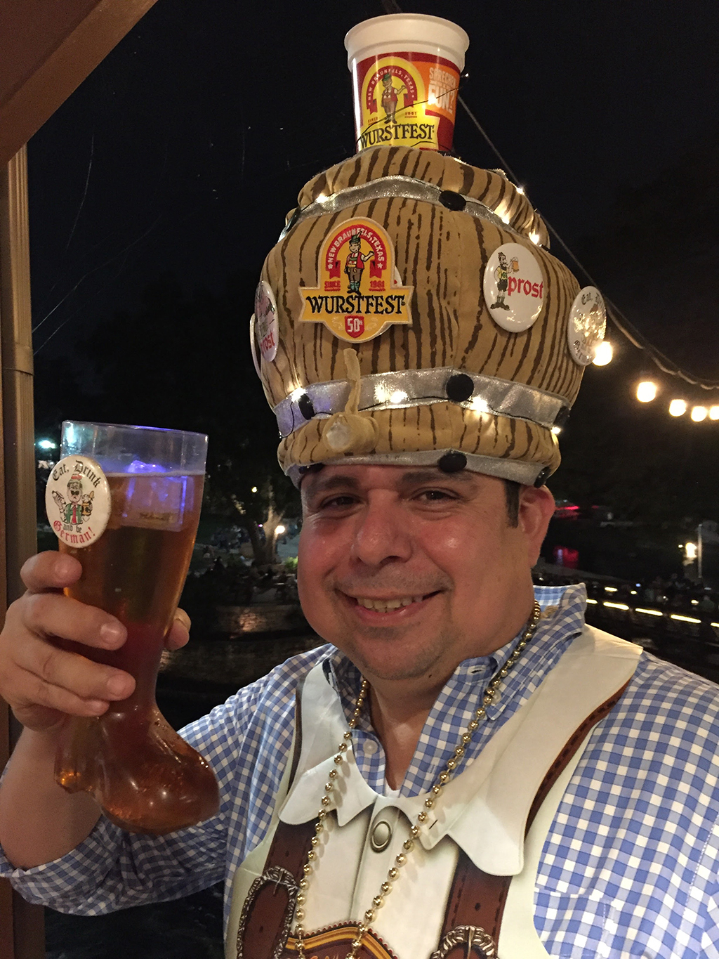 Wurstfest attendee wearing a hat, with a beer